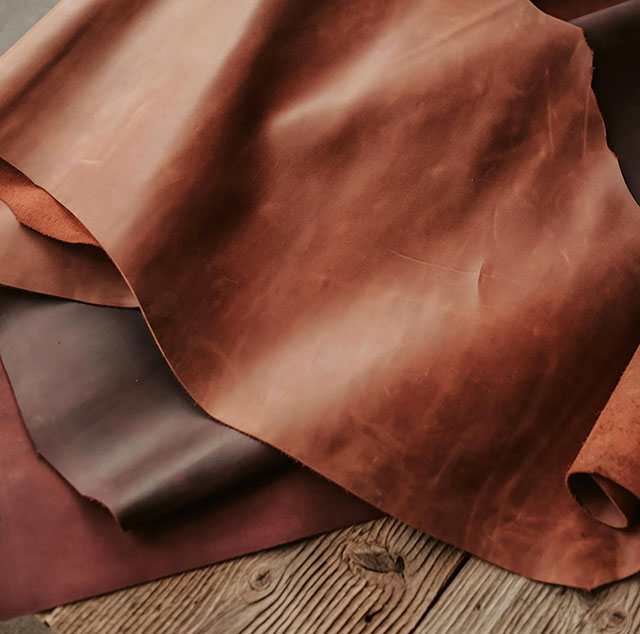 Various brown leather hides on wooden table