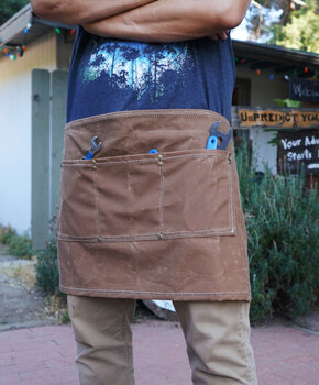 Half-size apron in brown canvas with wrenches in tool pockets