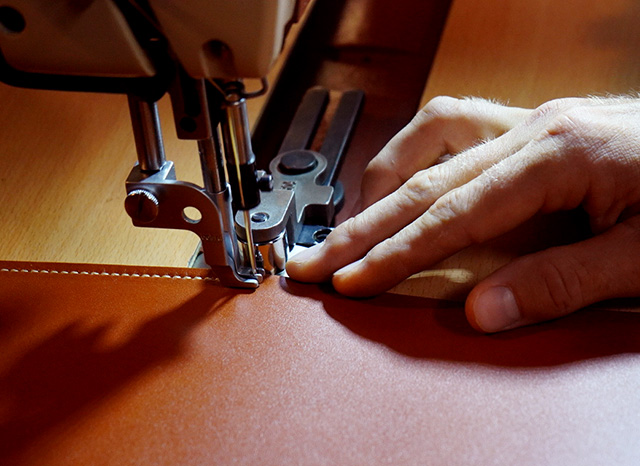 Leathersmith sewing a piece of leather